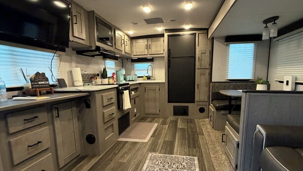 A modern kitchen with built-in appliances, wooden cabinets, and a central island.