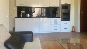 A modern kitchen with white cabinets, a black countertop, and stainless steel appliances. - Pool View 2 Bed at Holiday Fort Club (Sunny Beach)