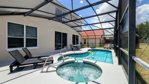 Une piscine extérieure couverte, dotée de chaises longues et d’un jacuzzi.