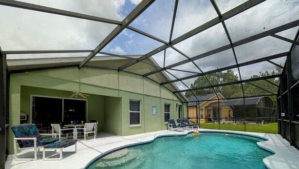 A covered swimming pool with lounge chairs and a patio area. - Sandy`s Sanctuary - Conservation View - South-West Facing Pool (Davenport)