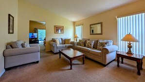 A living room with two sofas, a coffee table, and a TV in the background. - Sandy`s Sanctuary - Conservation View - South-West Facing Pool (Davenport)