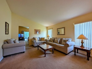 A living room with two sofas, a coffee table, and a TV in the background. - Sandy`s Sanctuary - Conservation View - South-West Facing Pool (Davenport)