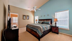 A bedroom with a bed, a desk, a chair, a ceiling fan, and two windows with blinds. - Sandy`s Sanctuary - Conservation View - South-West Facing Pool (Davenport)