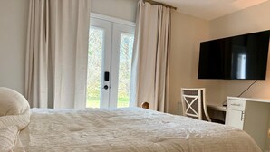 Ein Schlafzimmer mit Bett, Schreibtisch, Stuhl und Fernseher.