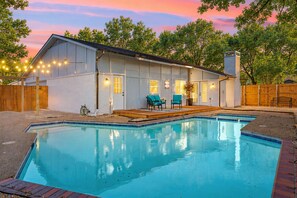 A house with a swimming pool, a deck, and a covered patio area. - Haven House | King Bed & Backyard + Pool (Richardson)