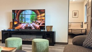 Ein Wohnzimmer mit Kamin, Fernseher und einer Couch.