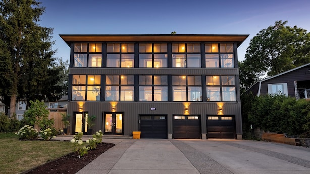 A modern two-story building with large windows, a garage, and a well-maintained front yard. - *NEW* Stunning Waterfront Mansion | Hot Tub | Falls (St. Catharines)