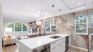 Une cuisine moderne dotée d’un grand îlot central, d’un four encastré et d’un évier.