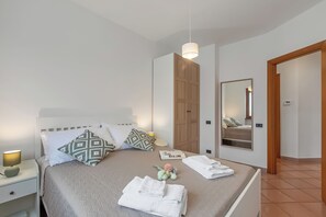 A neatly made bed with pillows, a bedside lamp, and towels. - Villa Adriana Capalbio with A/C, BBQ and Parking, Capalbio, Italy (Capalbio)