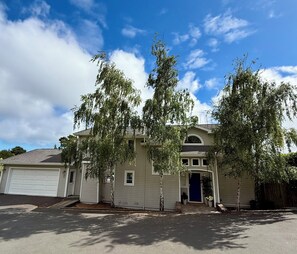 Ein zweigeschossiges Haus mit Garage, Veranda und Auffahrt.