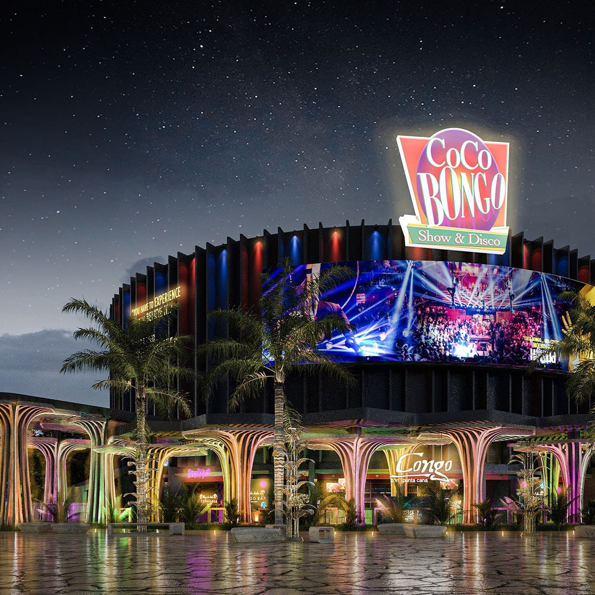 Ein großes, beleuchtetes Gebäude mit einem auffälligen 'Coco Bongo'-Schild, das eine Bühne und einen großen Bildschirm mit einer Konzertübertragung zeigt.