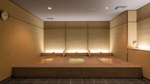 Une salle de bain moderne avec un grand miroir, un éclairage encastré et un sol carrelé.
