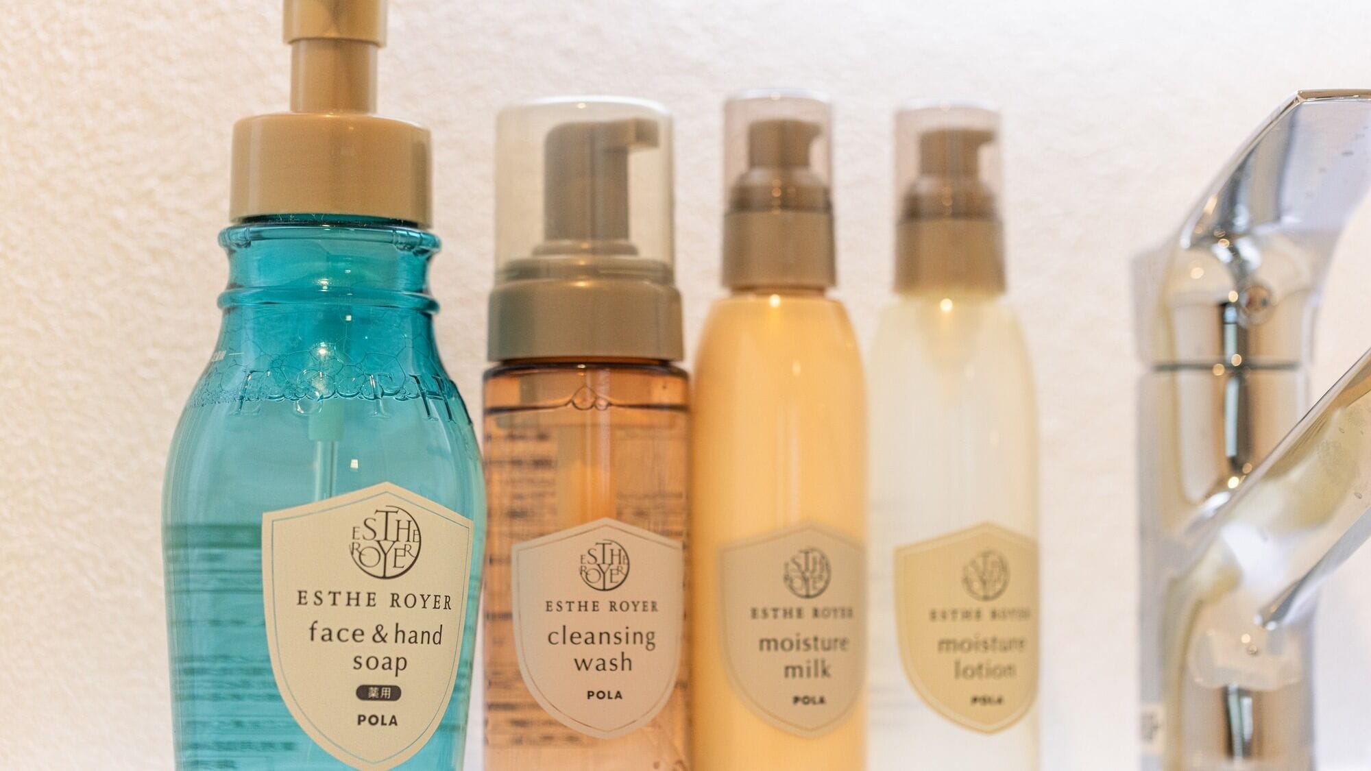 A row of ESTHE ROYER skincare products including face & hand soap, cleansing wash, and moisture milk.