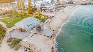 A beachfront property with a prominent building labeled 'Fremantle,' a wooden deck, and a sandy beach. - The Lookout – Modern Fremantle Apartment with View (Fremantle)