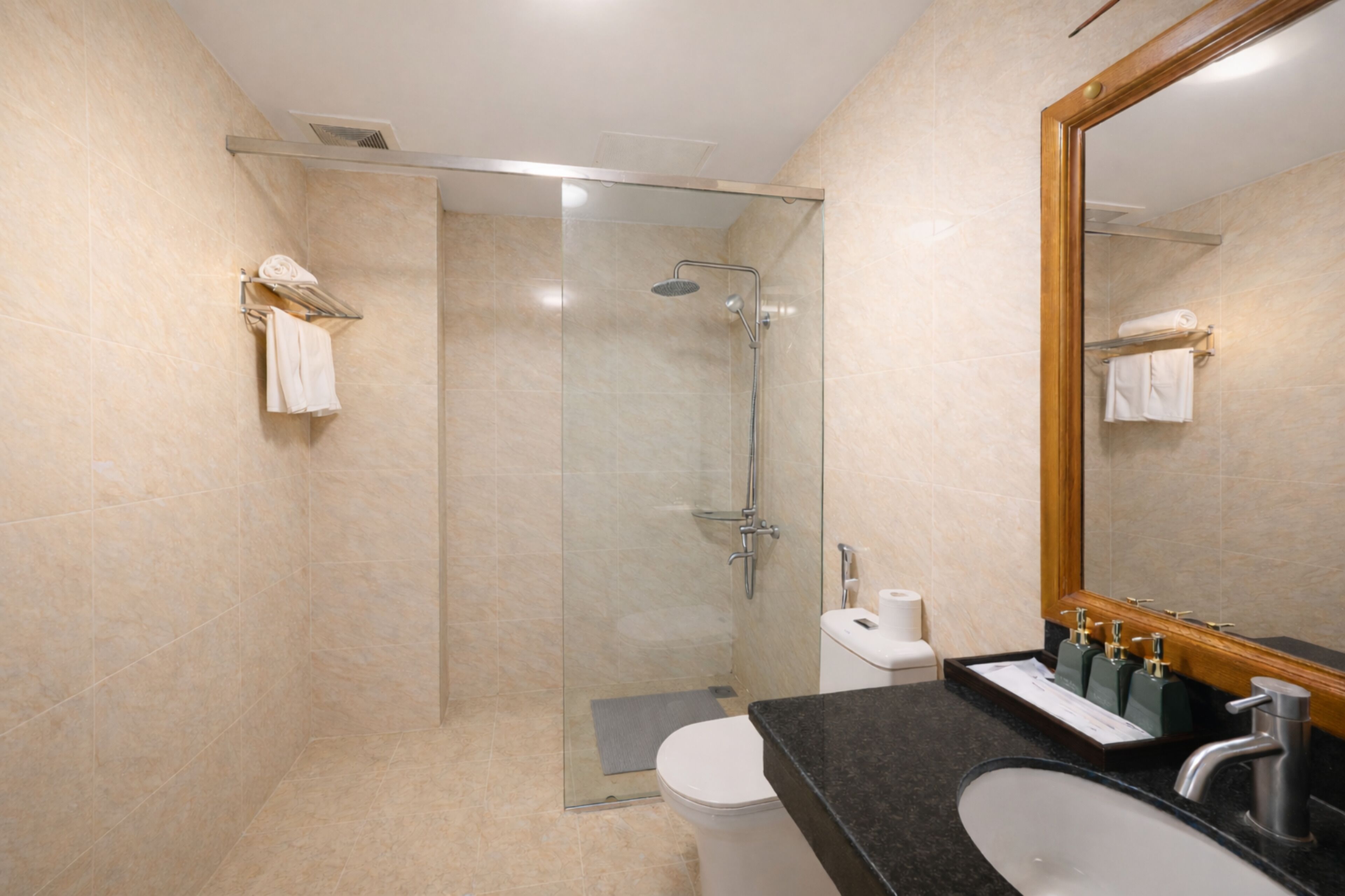 A modern bathroom with a glass-enclosed shower, a toilet, a sink with a mirror, and a towel rack.
