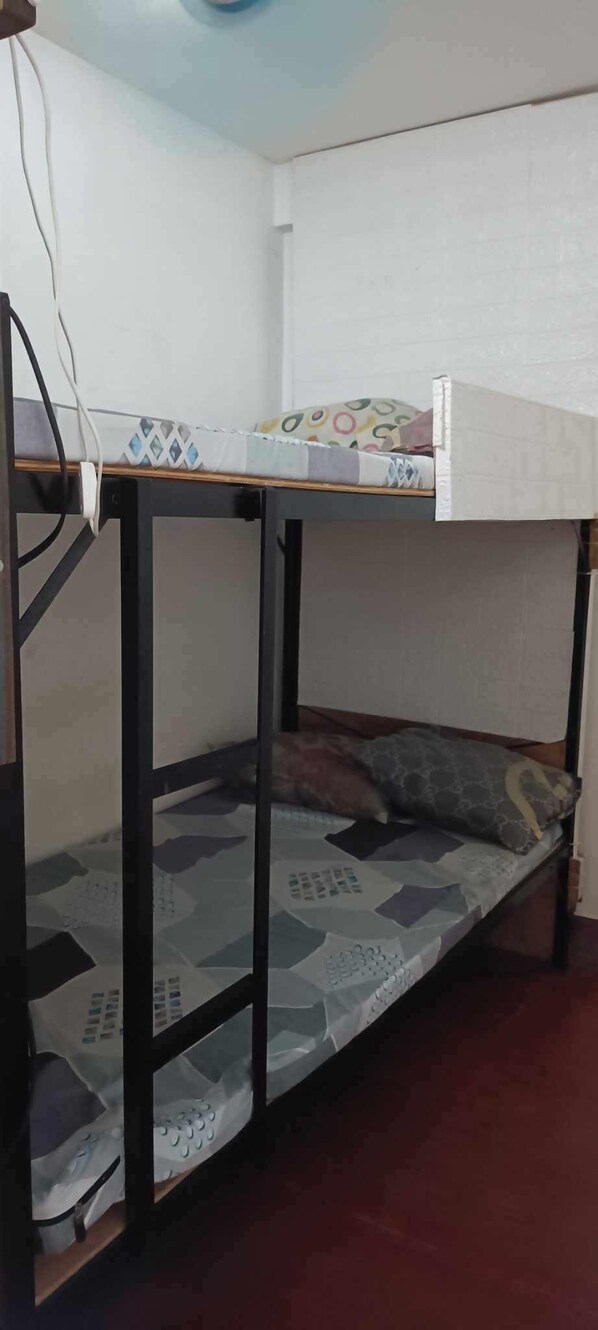 A bunk bed with a mattress featuring a geometric pattern, a pillow, and a white headboard. - Casa De gula (Valenzuela)
