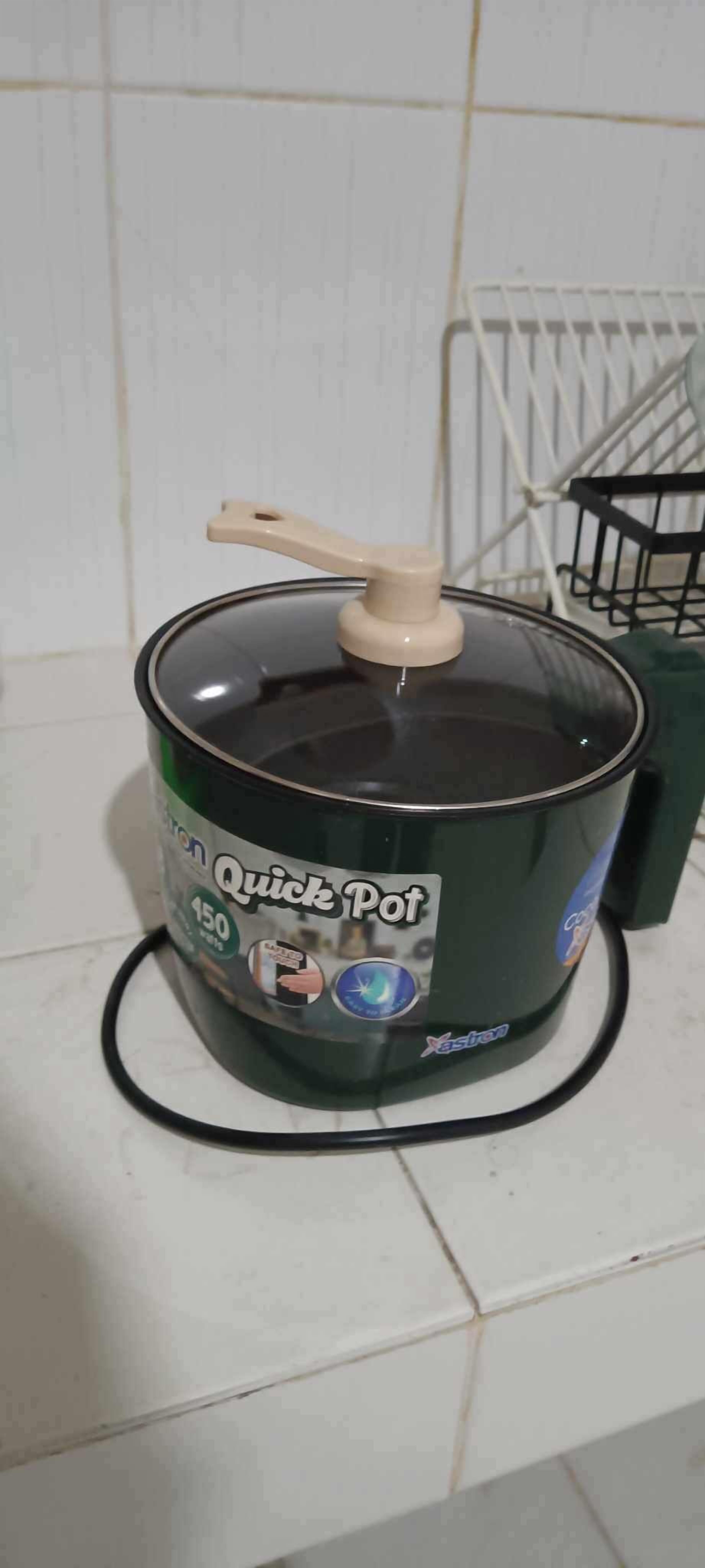 A kitchen with a cooking pot on a stove.