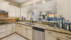 A kitchen with granite countertops, stainless steel appliances, and a large island. - 3BR Oceanfront Condo w/ Direct Beach Access & Pool (Holmes Beach)