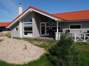A modern house with a red-tiled roof, large windows, and a deck. - Nordic-style Sanctuary With Sauna (Grossenbrode)