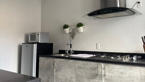 A modern kitchen with a built-in microwave, stainless steel appliances, a ceiling fan, and a gas stove. - Room with private bathroom in providencia (Guadalajara)