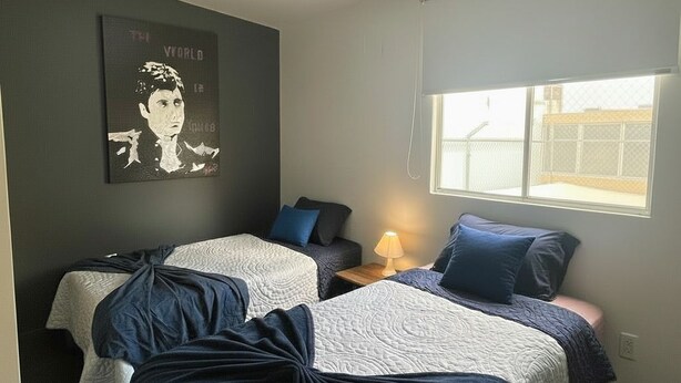 A bedroom with two beds, a window, a wall art piece, and a ceiling light. - MODERN ROOM PRIVATE BATHROOM IN EXCLUSIVE AREA (Guadalajara)