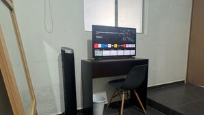 A room with a desk, a chair, a standing heater, and a window. - MODERN ROOM PRIVATE BATHROOM IN EXCLUSIVE AREA (Guadalajara)