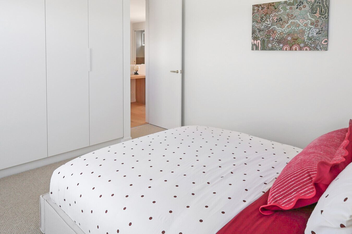 Ein Schlafzimmer mit einem Bett, einem Kleiderschrank und einer Tür zum Badezimmer.