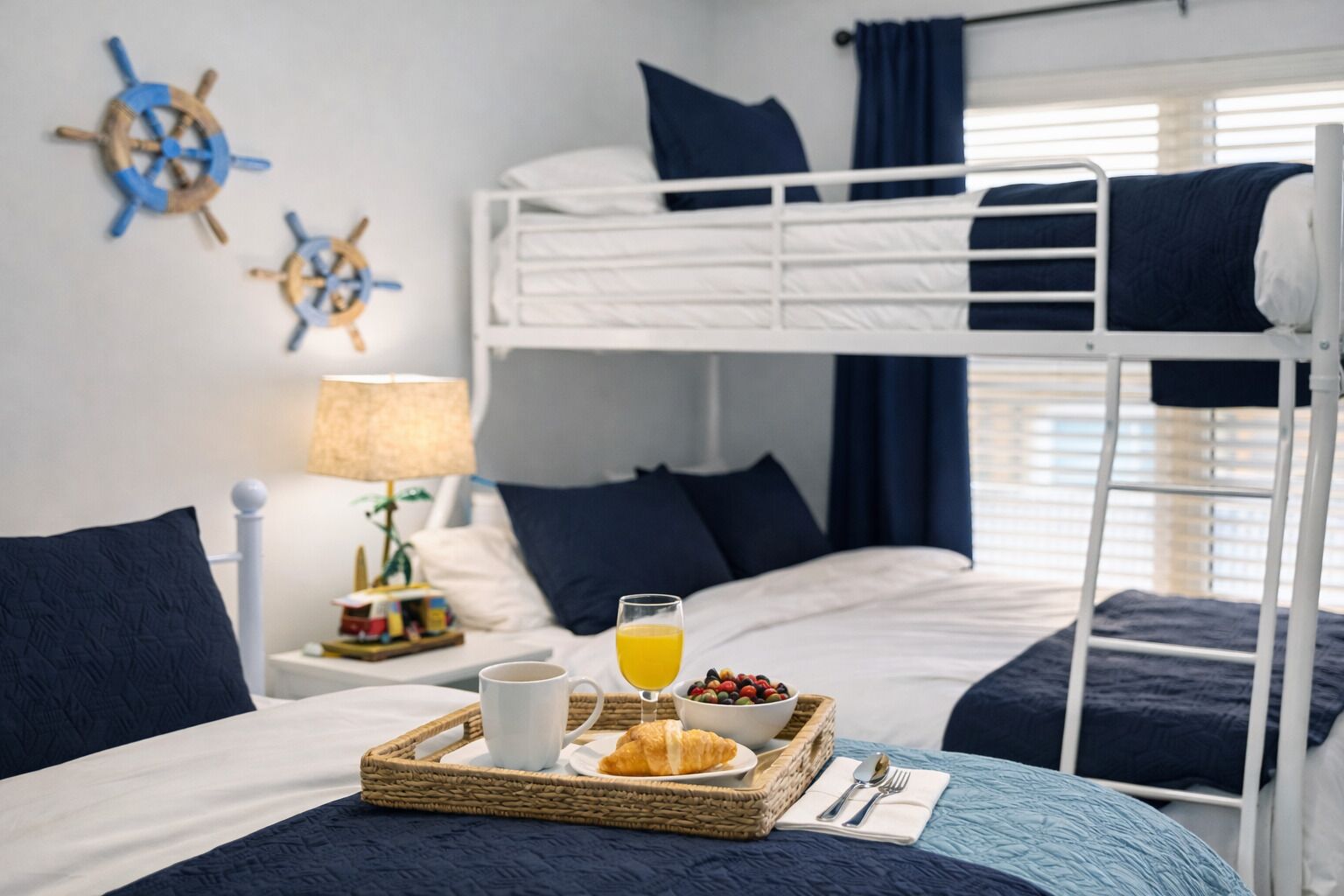 Camera con letto a castello, vassoio per la colazione, una tazza e un bicchiere di succo d'arancia.