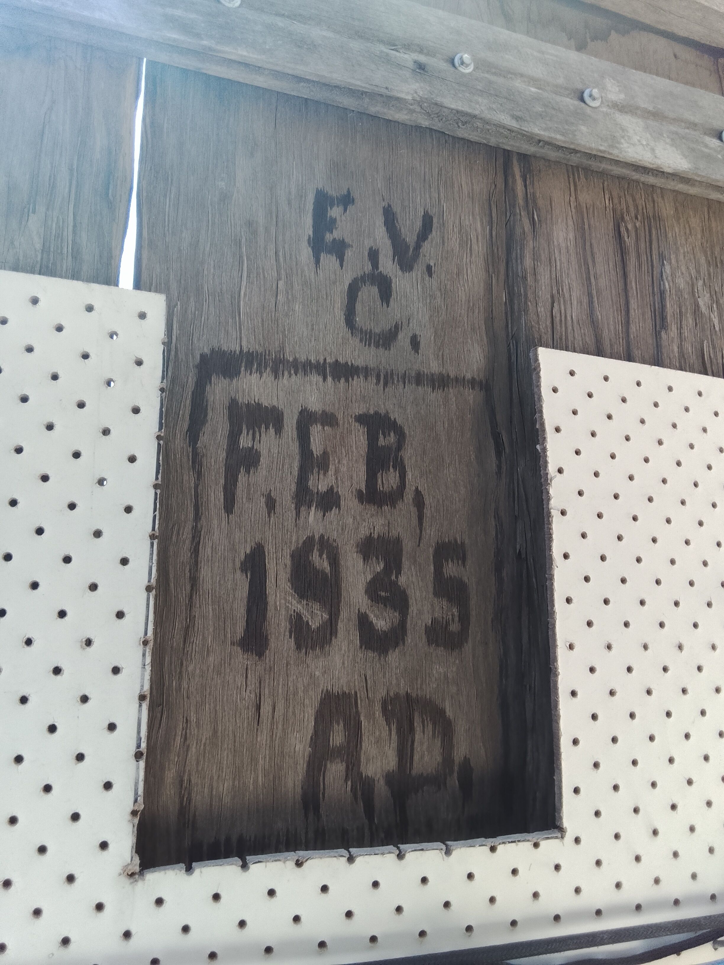 A wooden panel with stamped text 'F.V. C. FEB. 1935 AP.'