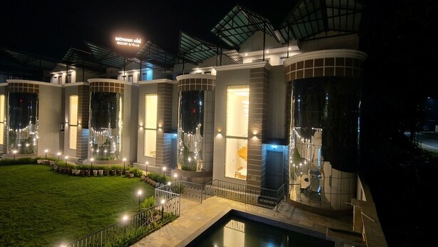Un hôtel moderne doté d’une entrée bien éclairée, d’un espace piscine et d’une enseigne indiquant le nom « Rocaby Villa ».