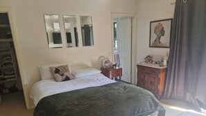 A bedroom with a bed, a dresser, a mirror, and a door. - Beautiful family home ,fully furnished in Bendigo over Easter 3rd April  to 8th (Strathdale)