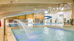 An indoor swimming pool with a water slide, a changing room area, and a visible staircase. - 20 Person Holiday Home in Skaerbaek (Skaerbaek)