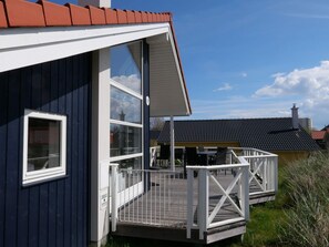 A coastal building with a deck, large windows, and a clear sky. - 4 Star Holiday Home in Grossenbrode (Grossenbrode)