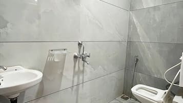 Een douche, een regendouche, pantoffels, handdoeken