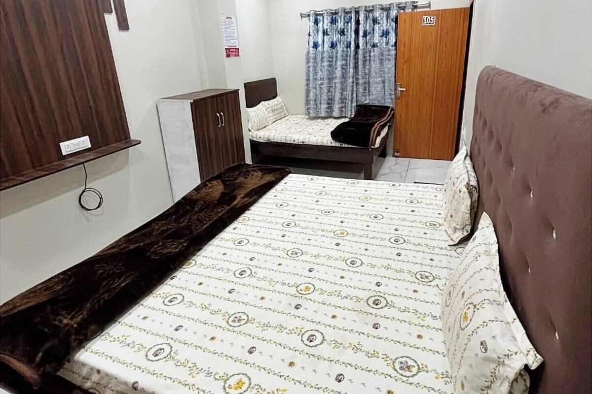 Un dormitorio con cama, armario, escritorio y puerta.