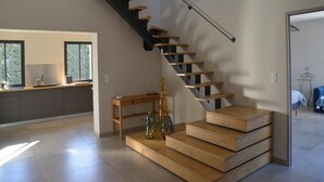 Un intérieur moderne avec un escalier, un ventilateur de plafond et un coin cuisine.