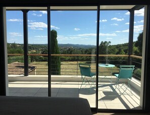 Ein Balkon mit Blick auf eine ländliche Landschaft, einem Tisch und zwei Stühlen.