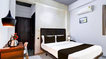 Ett modernt hotellrum med en säng, ett sängbord, en lampa, en luftkonditioneringsanläggning och en vägg med ett mönster.