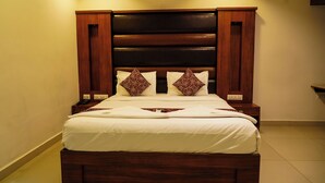 Ein Bett mit hölzernem Kopfteil, zwei Nachttische und einem Deckenventilator.