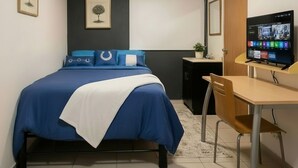 A bedroom with a bed, a desk, a chair, a television, and two framed pictures on the wall. - COZY ROOM IN PROVIDENCIA PUNTO SAO PAULO (Guadalajara)