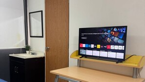 A room with a bed, a desk with a TV, a wooden door, and a small cabinet. - COZY ROOM IN PROVIDENCIA PUNTO SAO PAULO (Guadalajara)