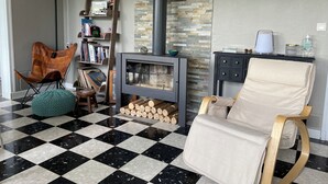 A living room with a fireplace, a checkered floor, a bookshelf, and a chair. - Architect's house in the countryside (Sainte-Geneviève-lès-Gasny)