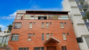 Un edificio de varios pisos con fachada de ladrillo, un cartel que dice 'Collection' y una escalera que conduce a la entrada.