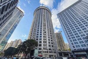 A tall, cylindrical building with a grid of windows, surrounded by other high-rise buildings. - Tyms High Serviced Residence Shanghai Stadium Metro (Shanghai)
