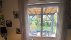 Une chambre à coucher avec un lit, une fenêtre donnant sur le jardin et un radiateur.