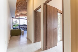 A hallway with a wooden door, a green sofa, and a view of the outdoors. - Historic Charm with Balcony in Downtown PV 2BD Condo for rent in Downtown, Puert (Puerto Vallarta)