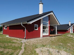 A red building with a large glass door and a chimney. - 4 Star Holiday Home in Grossenbrode (Grossenbrode)
