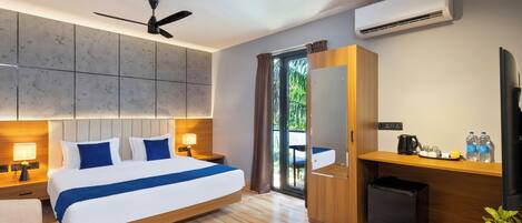 A modern hotel room with a large bed, a desk, a TV, an air conditioner, and a view of the outdoors.