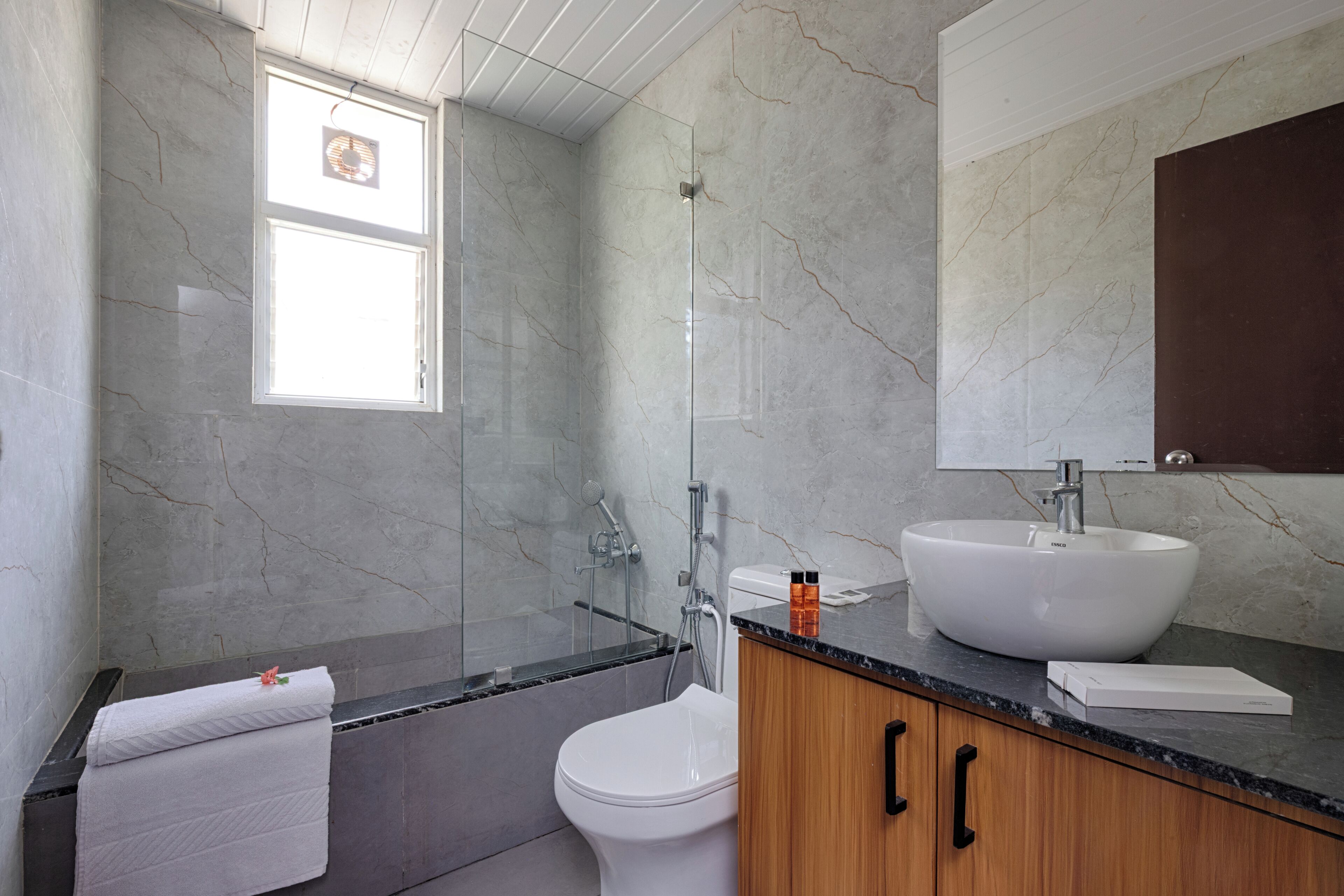 Une salle de bain avec une baignoire, des toilettes, un lavabo et une fenêtre.