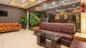 A modern lobby with a sofa, a coffee table, and a TV mounted on the wall.